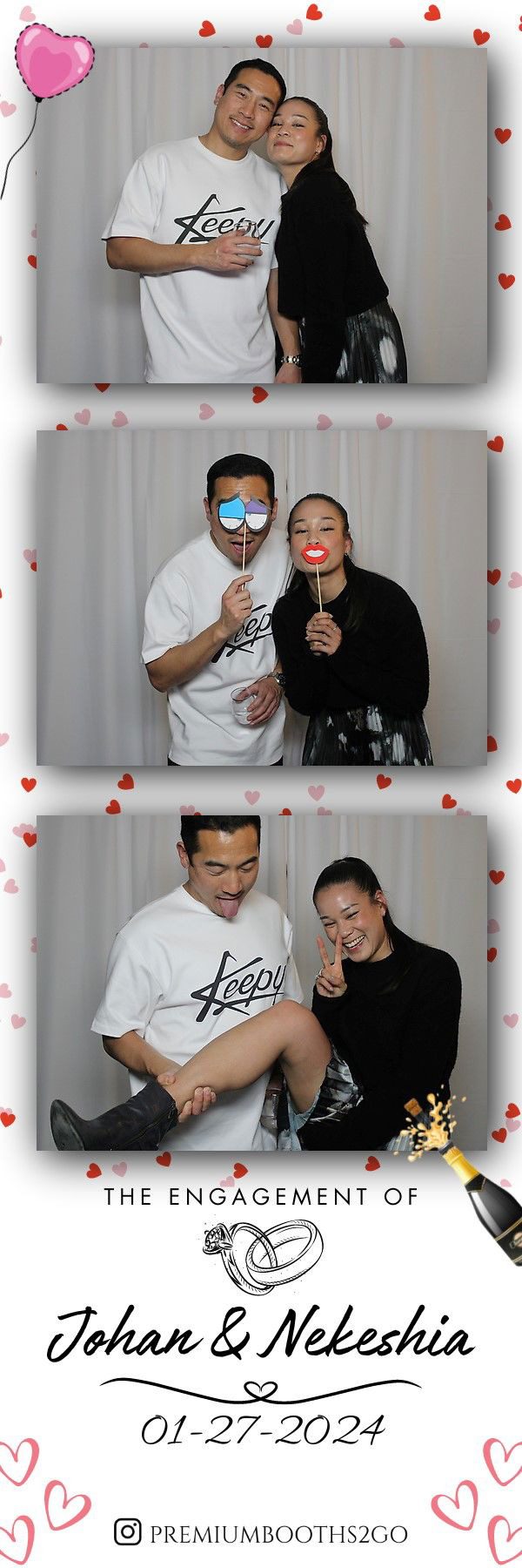 Two people posing with playful props in a photo booth with heart decorations.