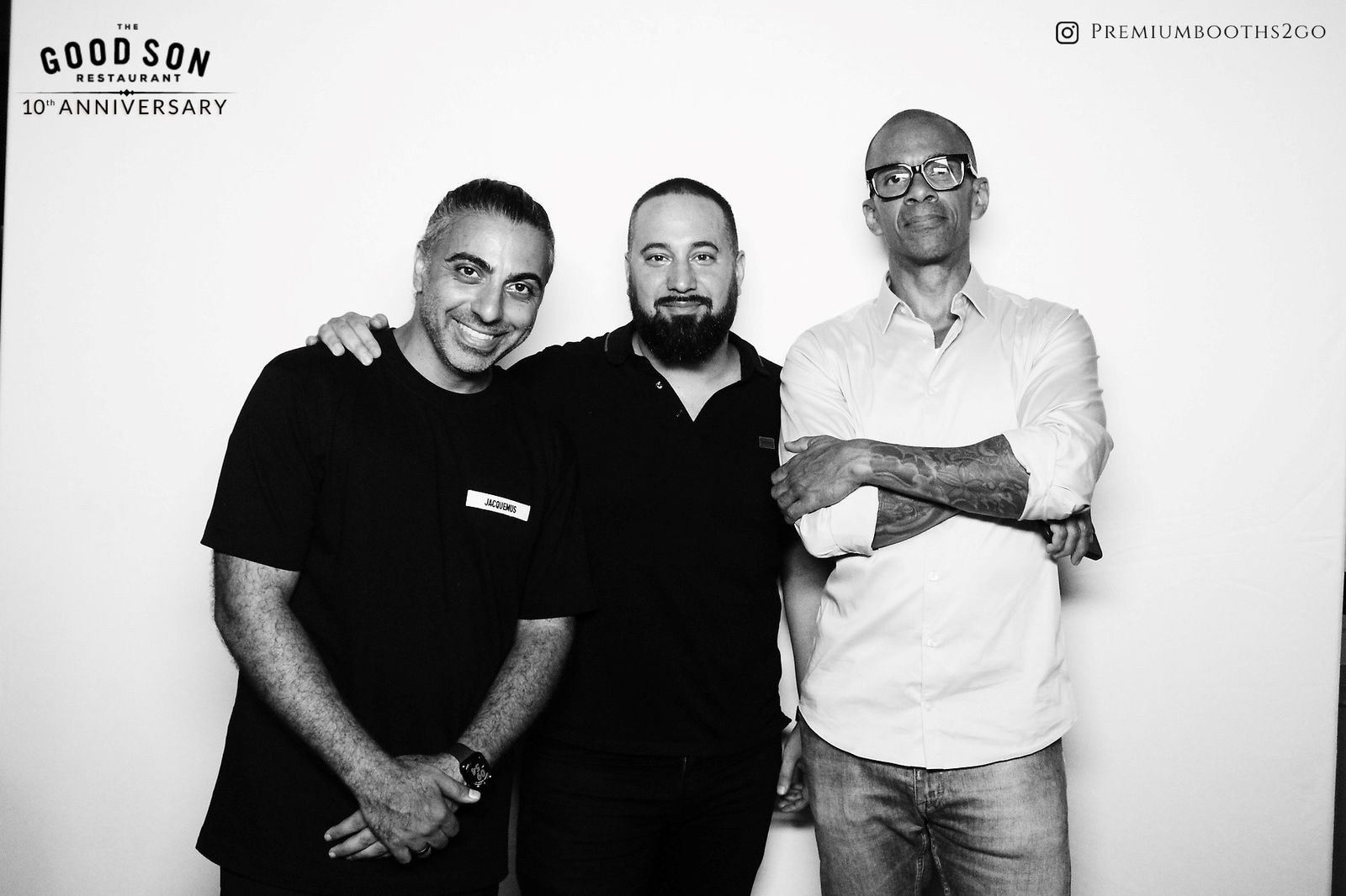Three men standing together, smiling and posing for a photo.
