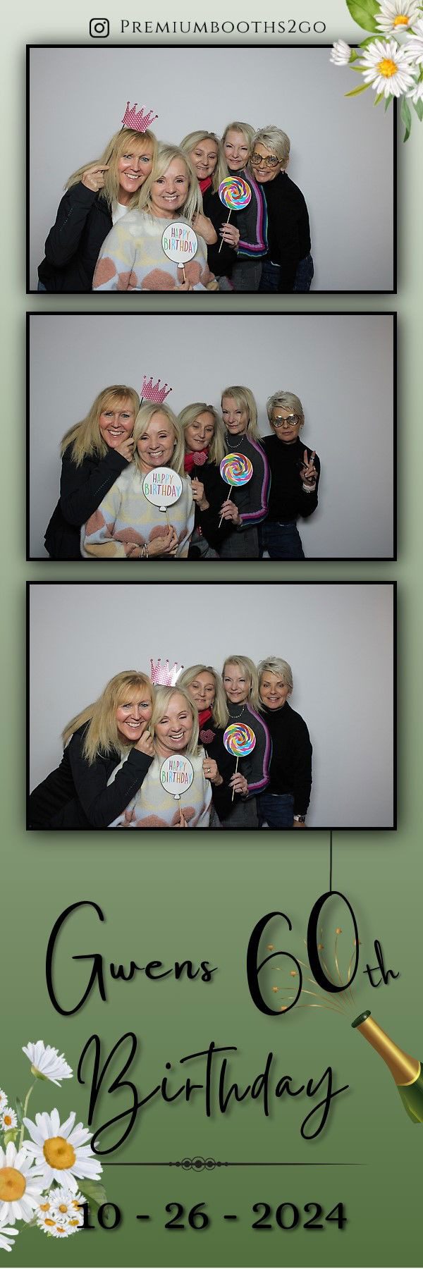 Group of five women smiling and holding decorative signs in a photo booth.