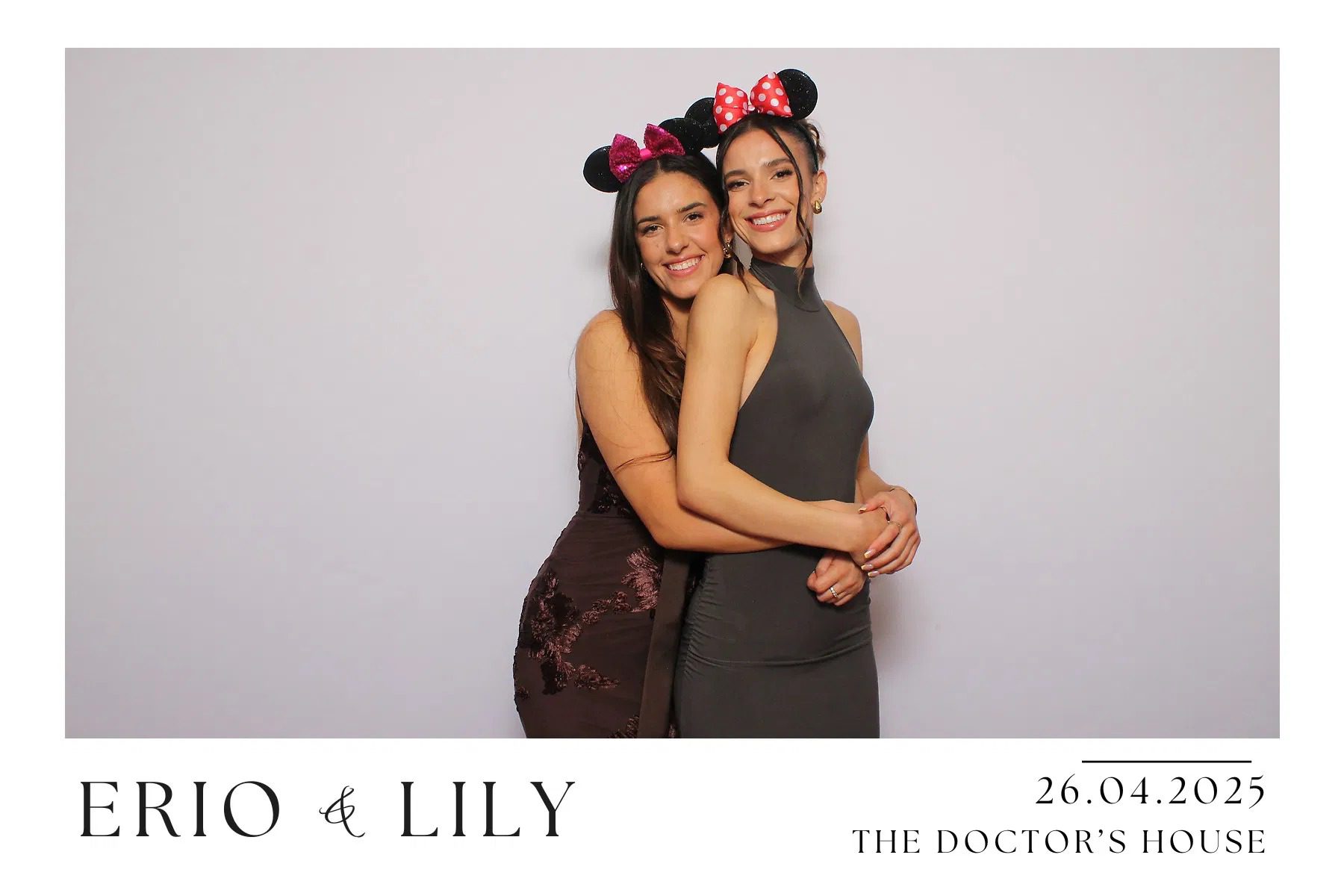 Two women smiling and hugging, wearing Minnie Mouse ears.